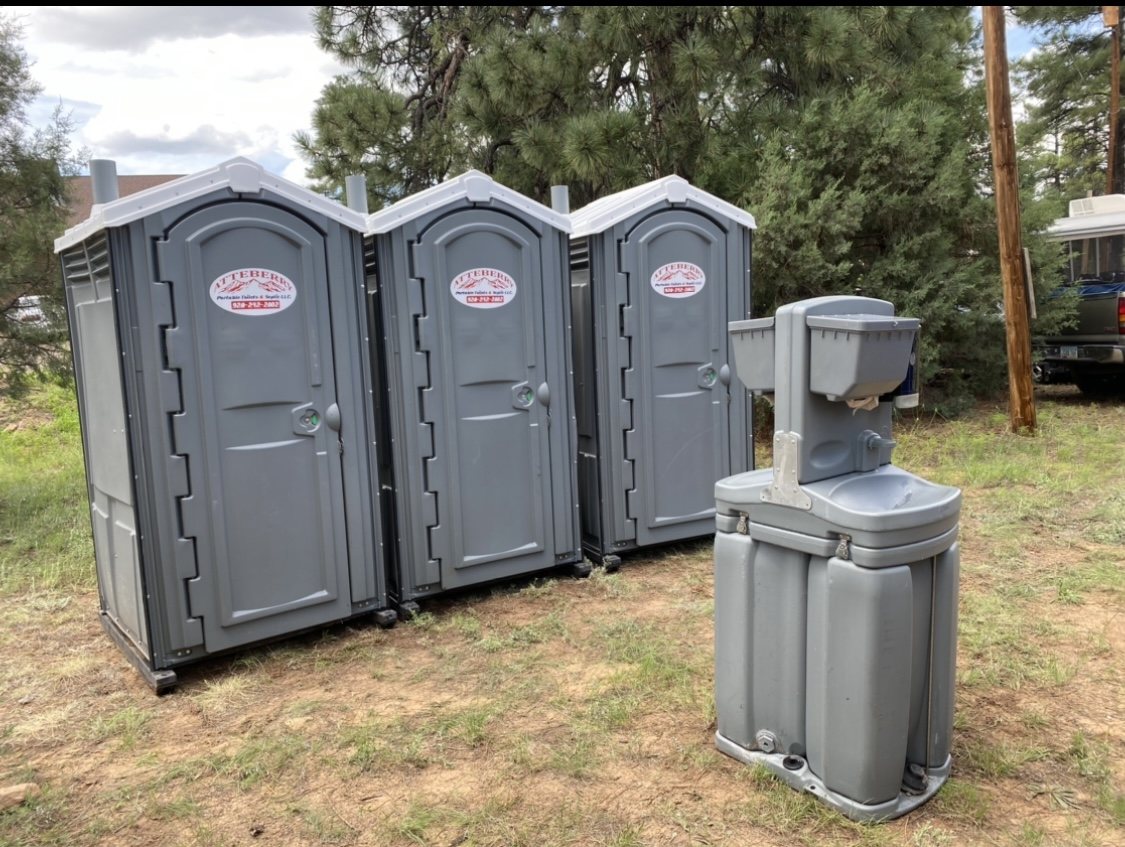 Atteberry portable toilets and a handwashing station set up on level ground