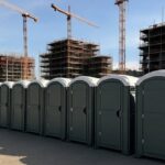 construction site showing proper porta potty placement near work zones with clear access paths